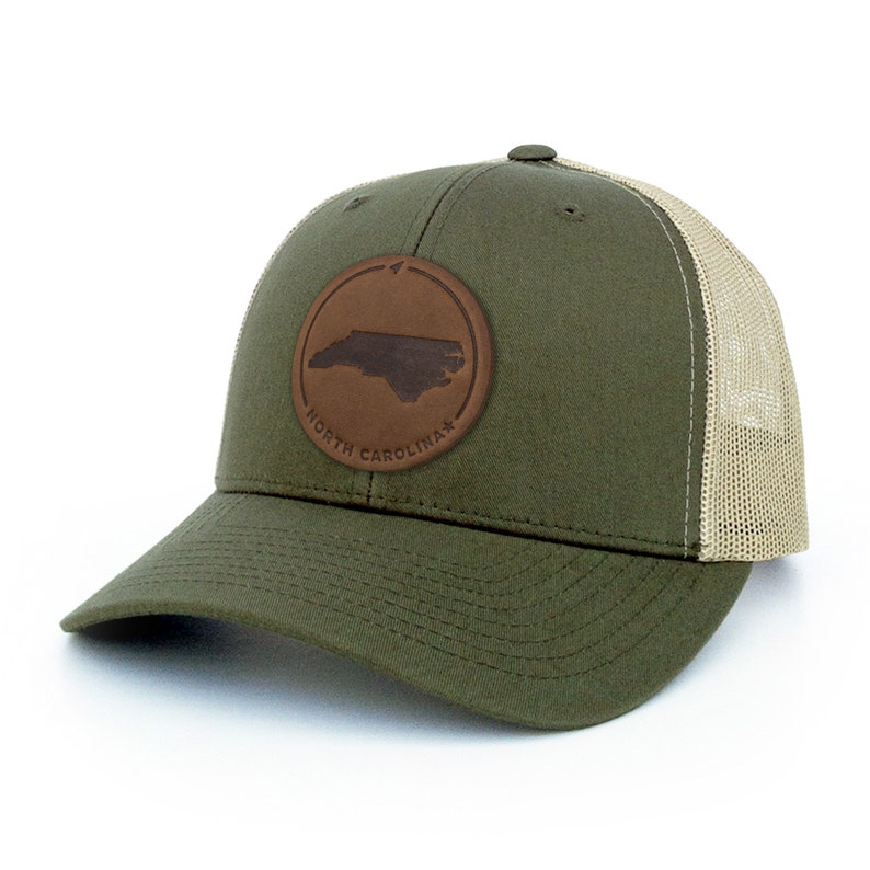 May include: A green and beige trucker hat with a brown leather patch featuring the outline of North Carolina and the text "NORTH CAROLINA".