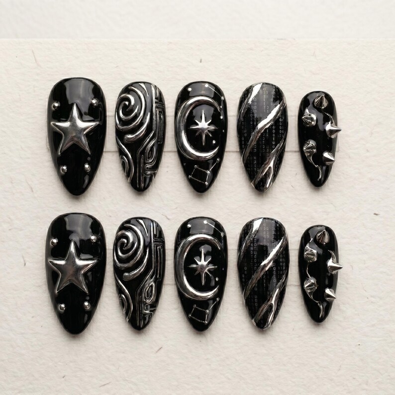 K&ouml;nnte beinhalten: Ein Set aus zehn mandelf&ouml;rmigen Press-on-N&auml;geln in gl&auml;nzendem Schwarz mit silbernen 3D-Verzierungen. Die Designs umfassen einen gro&szlig;en Stern, wirbelnde Metallmuster, einen Halbmond mit Stern, diagonale silberne Linien und kleine silberne Nieten.