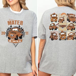 A gray t-shirt with a graphic design featuring multiple cartoon cars from the Cars movie franchise.
