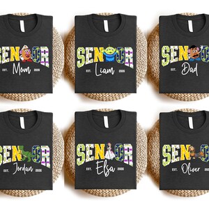 six black t-shirts with colorful text and characters, likely representing different individuals named Jordan, Elba, Oliver, and other names.