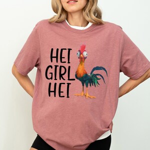 a woman wearing a pink shirt with a chicken on it