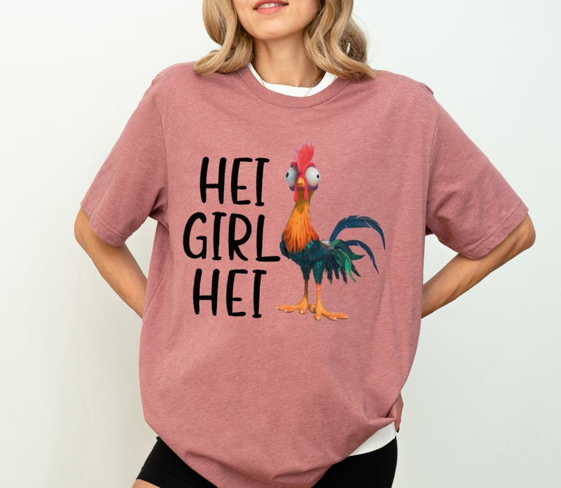 a woman wearing a pink shirt with a chicken on it