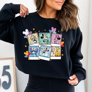 a woman wearing a mickey mouse sweatshirt and leggings