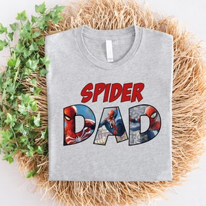 May include: Gray t-shirt with the text "Spider Dad" in red and a graphic of Spider-Man in red and blue.
