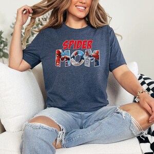 May include: A navy blue t-shirt with a graphic of Spider-Man characters forming the words "SPIDER MOM".