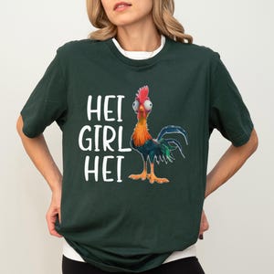 a woman wearing a green shirt with a rooster on it