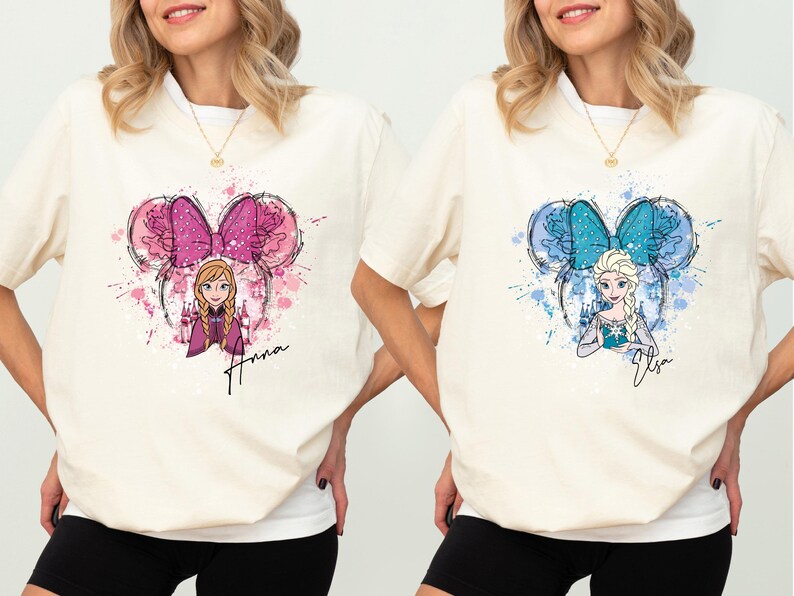 two women wearing matching shirts with cartoon characters on them