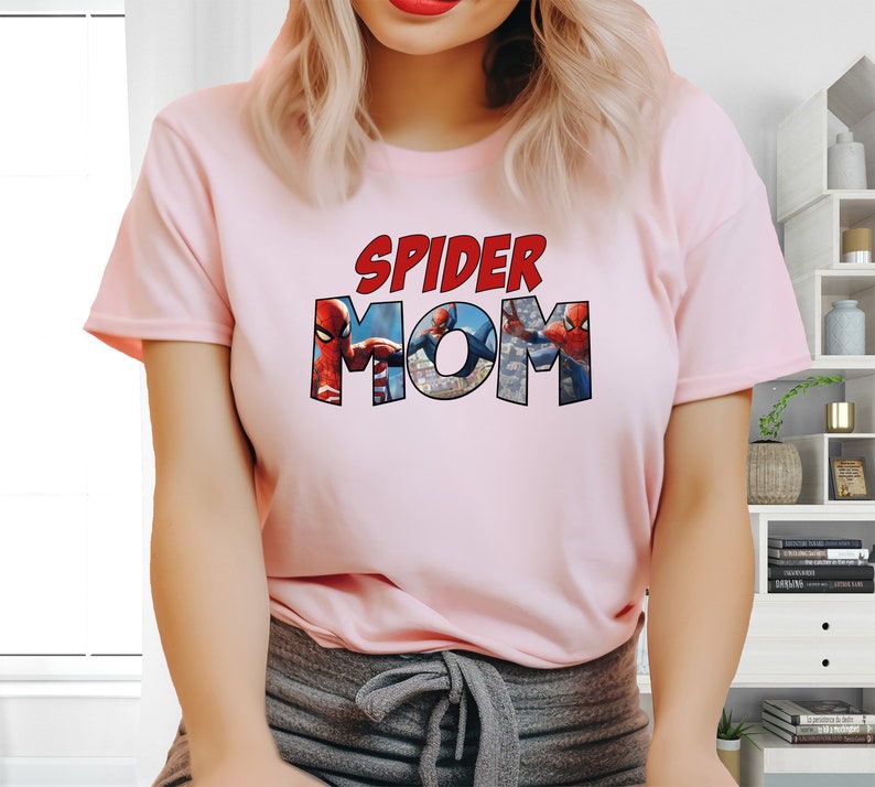 May include: Pink t-shirt with the text "SPIDER MOM" in red letters. The letters are made up of images of Spider-Man.