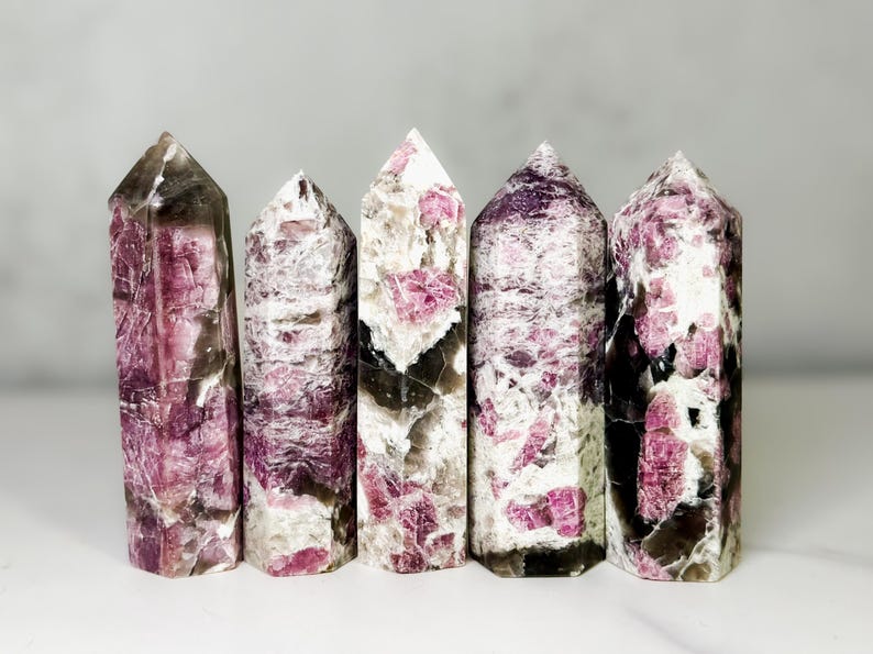 Pu&ograve; includere: Cinque torri di cristallo lucido con una miscela di rosa, bianco e grigio scuro. I cristalli hanno una forma colonnare con cime appuntite. L'estetica generale &egrave; naturale ed elegante, adatta all'arredamento della casa o alle pratiche spirituali.