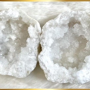 May include: Two halves of a white geode with a crystal interior. The geode is a natural rock formation with a hollow cavity lined with crystals.