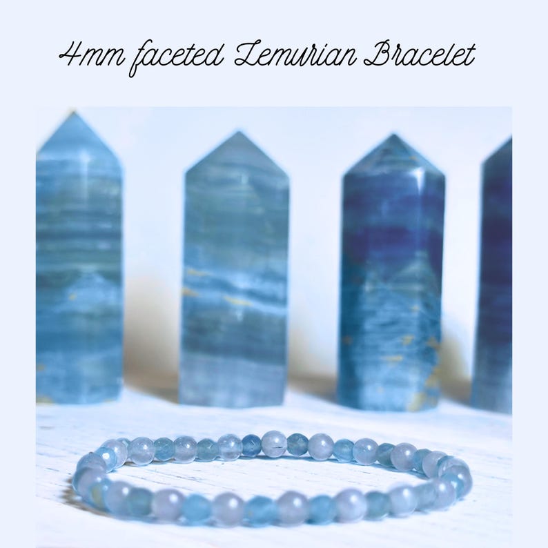 Puede incluir: Un brazalete de cristal de Lemuria azul claro con cuentas facetadas de 4 mm. El brazalete est&aacute; sobre una superficie blanca delante de cuatro puntas de cristal de Lemuria m&aacute;s grandes.