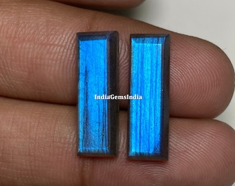 May include: Two rectangular labradorite gemstones with a blue iridescent sheen. The stones are set in a bezel setting and have a polished finish.