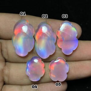 May include: Five opalescent gemstones with a flower-like shape. The stones display a range of colors, including pink, blue, and green, with a pearly iridescence. Each stone is numbered from 01 to 05.