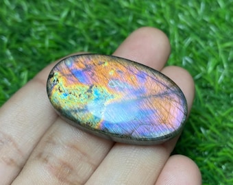 May include: A large oval-shaped labradorite gemstone with iridescent colours, including blue, green, orange, and purple.
