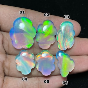 May include: Six opals with a flower-like shape are displayed. Each opal has a unique color pattern, with hues of green, blue, and yellow. The opals are numbered 01 through 06. The opals are held in a hand against a dark background.