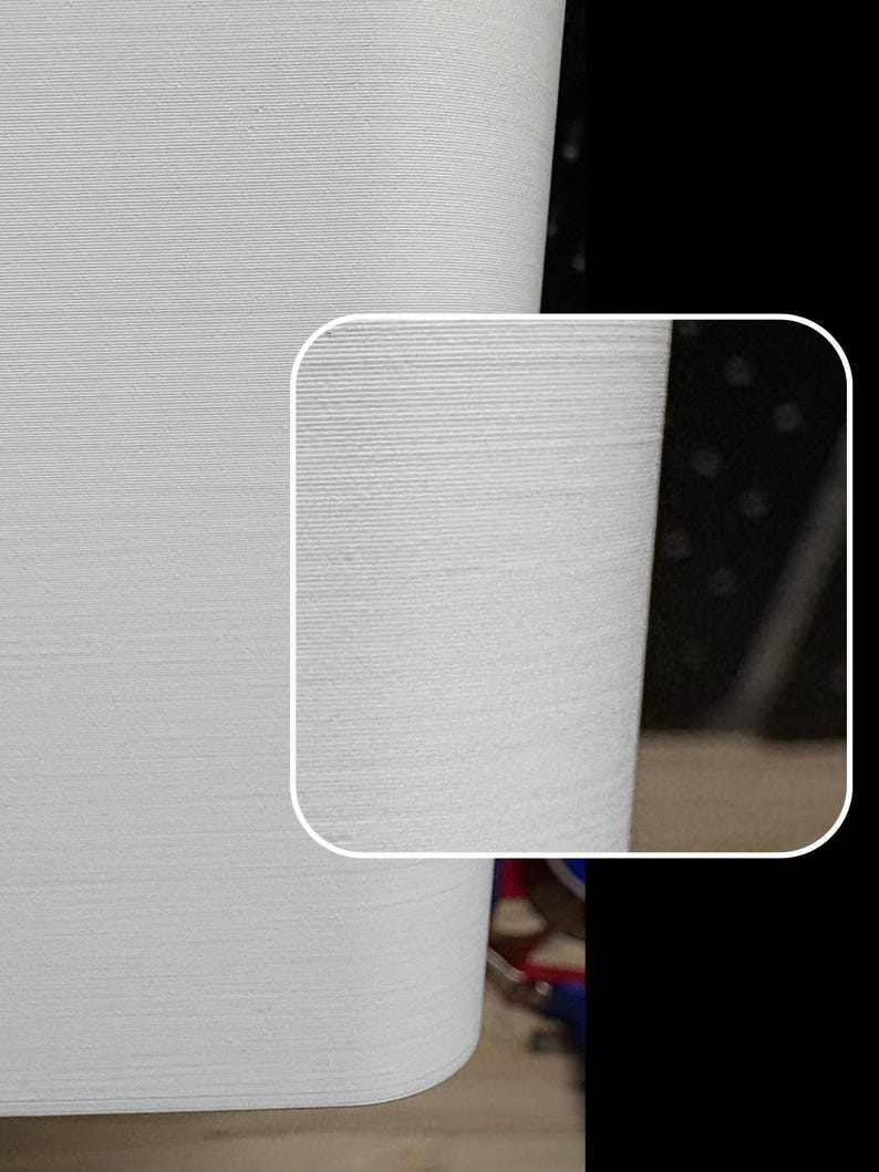 May include: Close-up of a white, textured surface with a slightly curved edge. The surface has a subtle, horizontal pattern.