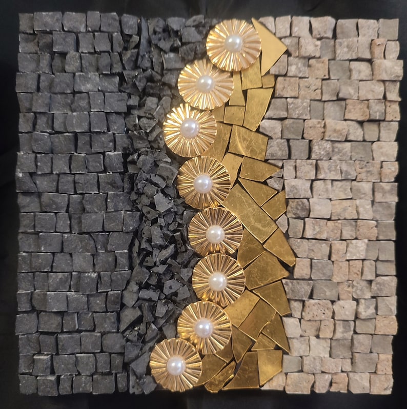 May include: A mosaic art piece with a black and white background and a gold and white design. The design is a series of overlapping circles with a pearl in the center of each circle.