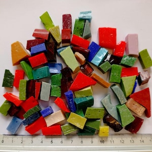 Könnte beinhalten: Eine Sammlung bunter Mosaikfliesen in verschiedenen Formen und Größen. Die Fliesen sind in Rot-, Grün-, Blau-, Gelb- und Orangetönen gehalten. Ein Lineal am unteren Rand zeigt die Maße in Zentimetern an.