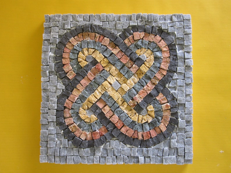 May include: A mosaic tile artwork featuring a geometric pattern of interlocking loops in shades of gray, black, red, yellow, and beige.