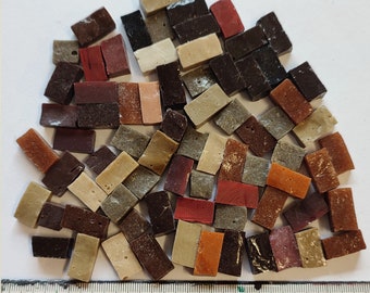 May include: A collection of small, rectangular mosaic tiles in various shades of brown, red, and beige. The tiles are arranged in a random pattern and are approximately 1 inch in length.