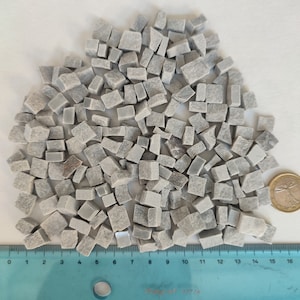 Könnte beinhalten: Ein Haufen kleiner, grauer, unregelmäßig geformter Steinplatten. Die Platten sind etwa 1,25 cm groß und in einem zufälligen Muster angeordnet. Ein Lineal ist am unteren Rand des Bildes sichtbar, mit Markierungen von 0 bis 40 cm.