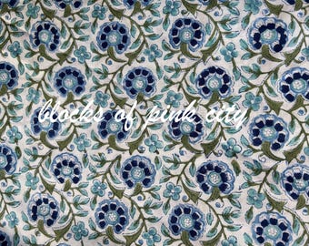 May include: Floral fabric with a repeating pattern of blue flowers and green leaves on a white background. The text "blocks of pink city" is written across the fabric in a cursive font.