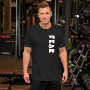 May include: A black t-shirt with a white graphic that says "FEAR" with a red line through it. The shirt is being worn by a person in a gym setting.