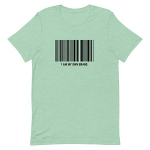 Könnte beinhalten: Hellgrünes T-Shirt mit schwarzem Barcode-Design und dem Text "I AM MY OWN BRAND". Das Shirt hat einen Rundhalsausschnitt und besteht aus weichem Material.
