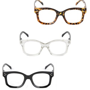 May include: Three pairs of spectacles are shown against a white backdrop. The top pair has a tortoiseshell pattern, the middle pair is clear, and the bottom pair is black. All have rectangular frames.