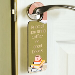 May include: A brown door hanger with the text "Knock if you bring coffee or good books!" and a cartoon illustration of a coffee cup and a stack of books.