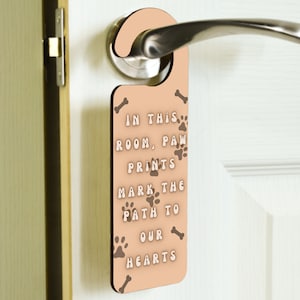 I detta rum markerar tassavtryck vägen till våra hjärtan – Dörrhandtagshängare i plywood (doorh-kf23-markpath)