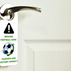 May include: White door hanger with a black warning sign and a soccer ball graphic. The text reads "Beware: Football Zone Passion and Victory Inside!"