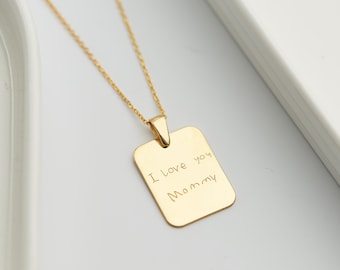 Puede incluir: Collar de oro con un colgante rectangular grabado con el mensaje "Te amo Mamá".