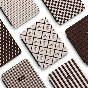 Può includere: Una collezione di custodie rettangolari per e-reader con vari motivi marroni e crema, tra cui pois, quadrati a scacchi, strisce e una griglia a rombi con icone di fiocchi. Diverse custodie sono personalizzate con il nome Olivia in testo.