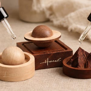 Pode incluir: Um conjunto de três canecas de cerâmica com acabamento fosco e salpicado. As canecas são em tons de creme, cinza claro e cinza escuro. Cada caneca tem um design simples e minimalista.