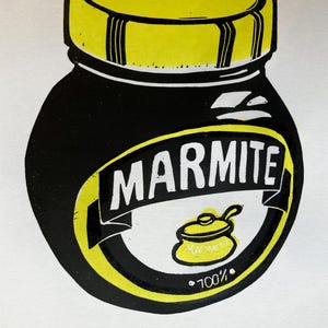 May include: A black and yellow illustration of a jar of Marmite, a popular yeast extract spread. The jar has a yellow lid and the word "Marmite" is printed in white letters on the front. The text "100%" is printed in white letters below a small yellow pot with a handle.