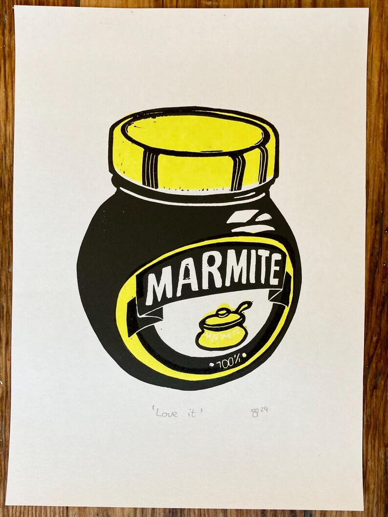 May include: A black and yellow illustration of a jar of Marmite spread. The jar has a yellow lid and a label that says "Marmite" in black letters. The label also has a small yellow pot with a spoon inside and the text "100%". The text "Love it" and the number "829" are written below the jar.