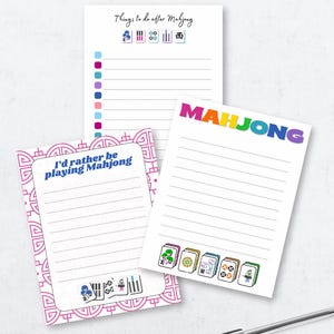 May include: Three lined notepads with Mahjong-themed designs. One notepad has the text "Things to do after Mahjong" and Mahjong tile illustrations. Another says "I'd rather be playing Mahjong". The third notepad says "MAHJONG" in rainbow colors.
