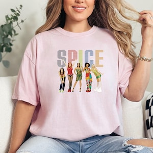 a woman sitting on a couch wearing a pink t - shirt