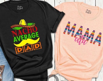 May include: Two t-shirts with a Cinco de Mayo theme. The black t-shirt has a cartoon image of a sombrero and the text "Nacho Average Dad". The peach t-shirt has the text "Mamacita" in colorful letters.