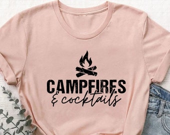 May include: A pink t-shirt with a black graphic of a campfire and the text "Campfires & cocktails".