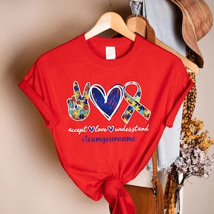 a red shirt with a heart and two hands on it