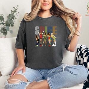 a woman sitting on a couch wearing a t - shirt that says spice