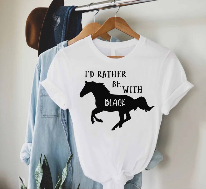 May include: White t-shirt with a black silhouette of a horse and the text "I'd rather be with black".