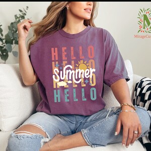 a woman sitting on a couch wearing a t - shirt that says hello summer hello