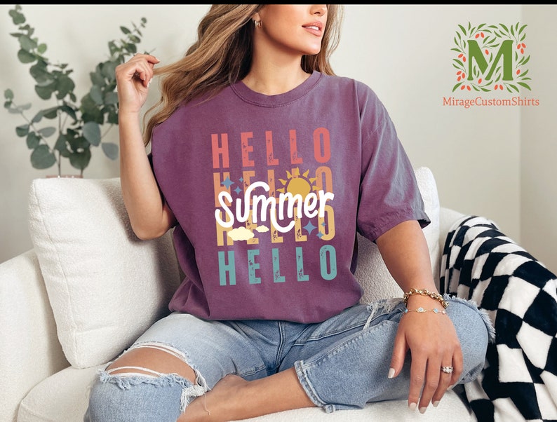 a woman sitting on a couch wearing a t - shirt that says hello summer hello