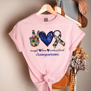 a pink shirt with a peace sign and two hearts