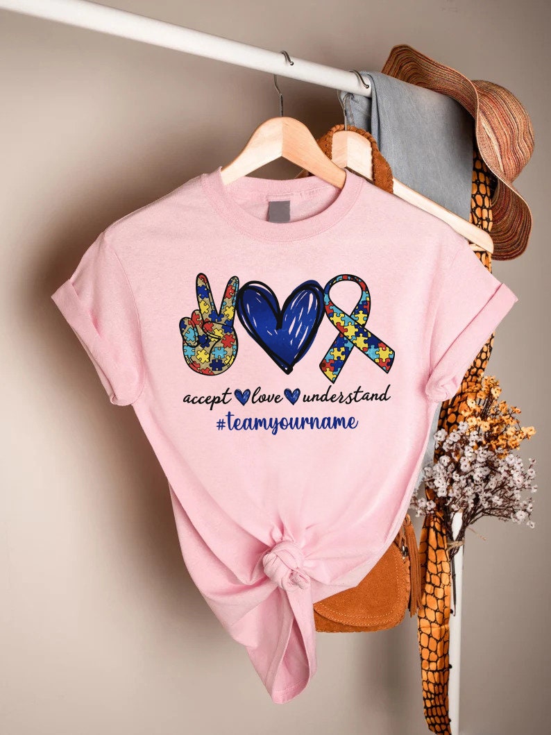 a pink shirt with a peace sign and two hearts
