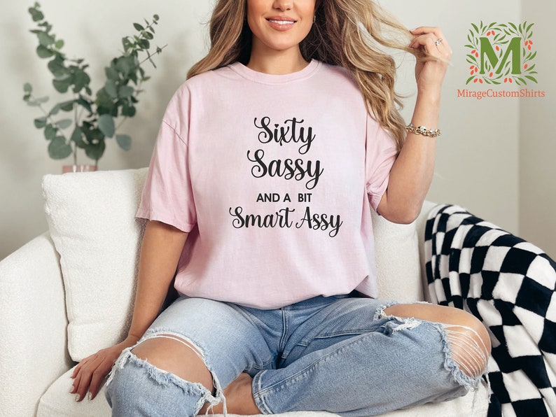 a woman sitting on a couch wearing a pink shirt