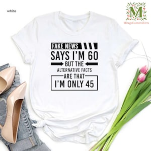 a t - shirt that says fake news says i'm 60 but the alternative